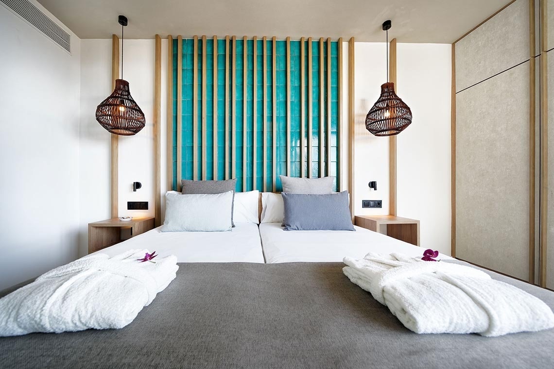 una habitación con una cama y dos lámparas colgando del techo