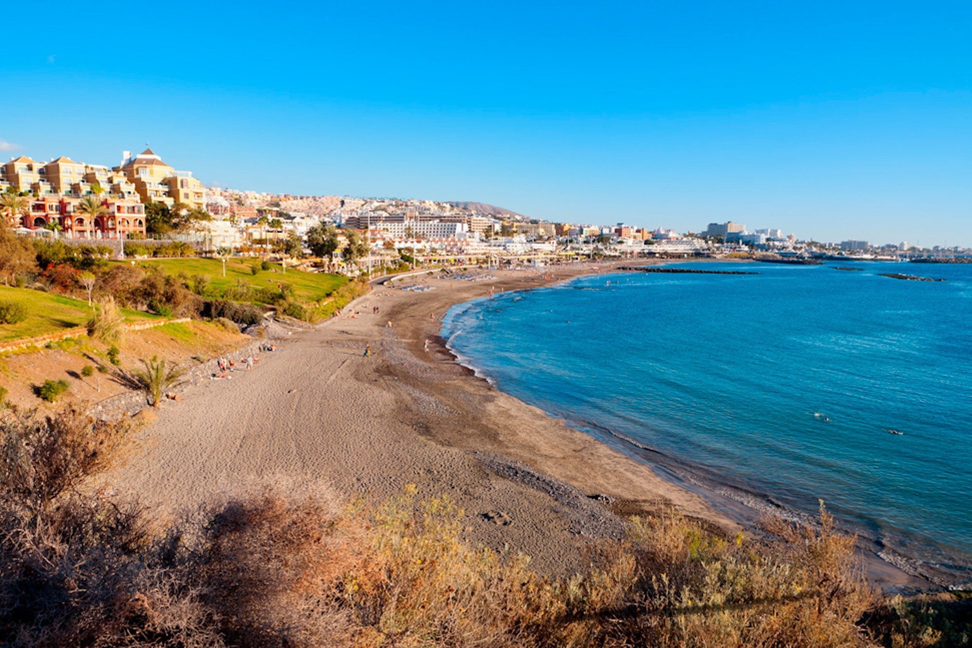 вид на пляж с городом на заднем плане