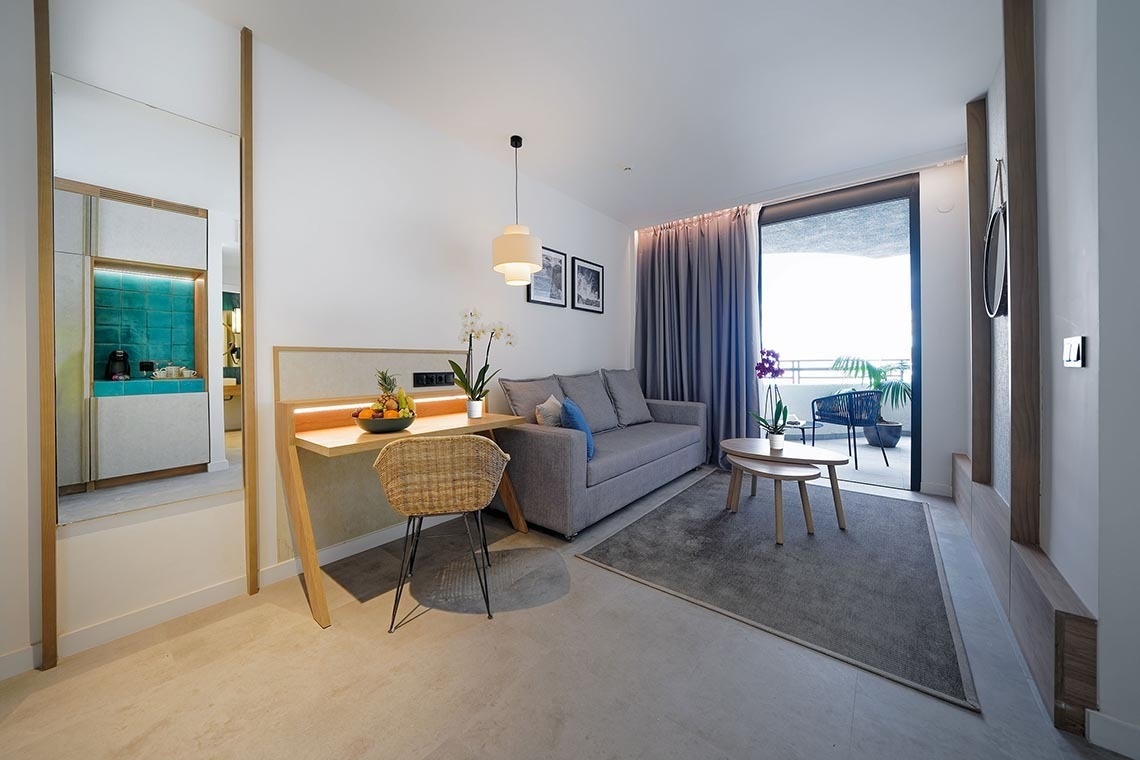 dos sillas y una mesa en un balcón con un árbol en el fondo