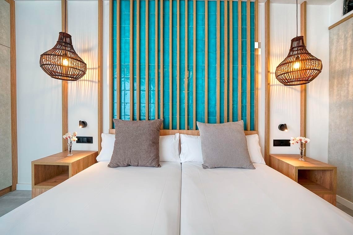 una habitación con una cama y dos lámparas colgando de la pared