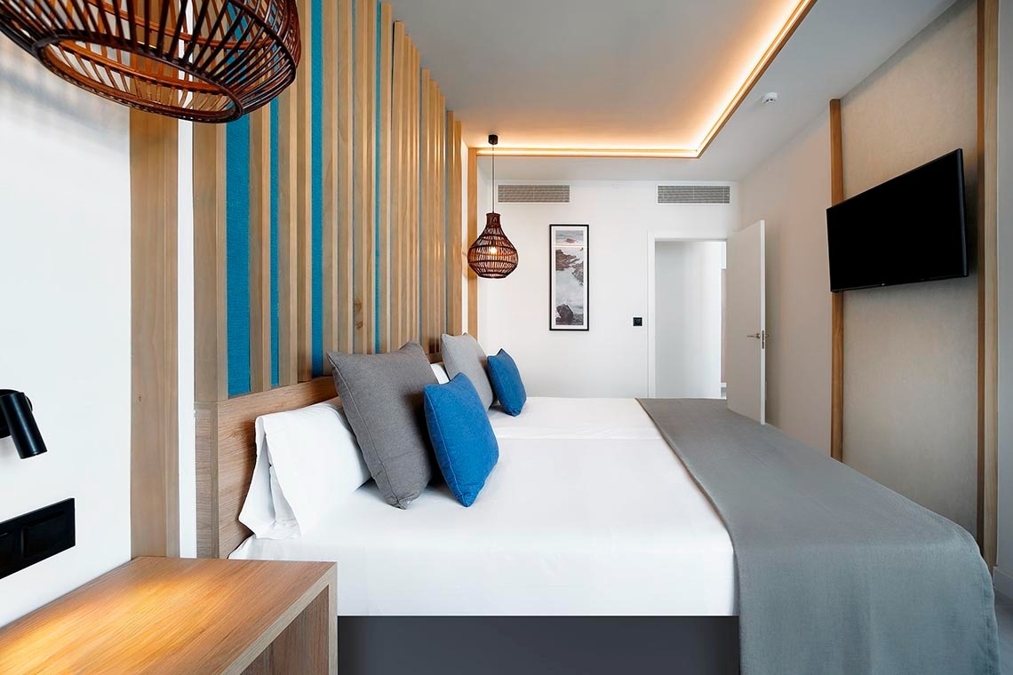 una habitación con dos camas y dos mesitas de noche