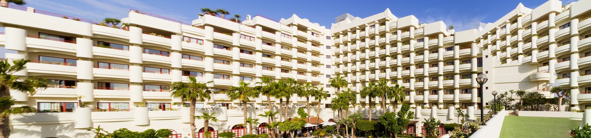 a large white building with palm trees in front of it