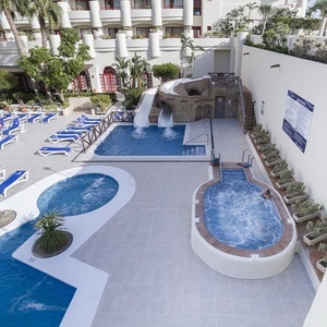 una piscina con un tobogán y un jacuzzi en un hotel