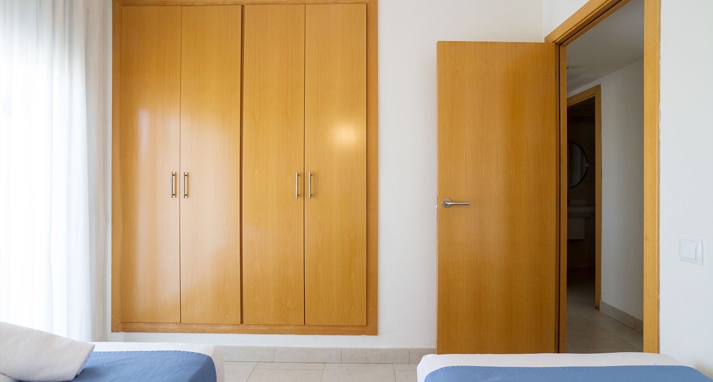 un dormitorio con dos camas y un armario de madera