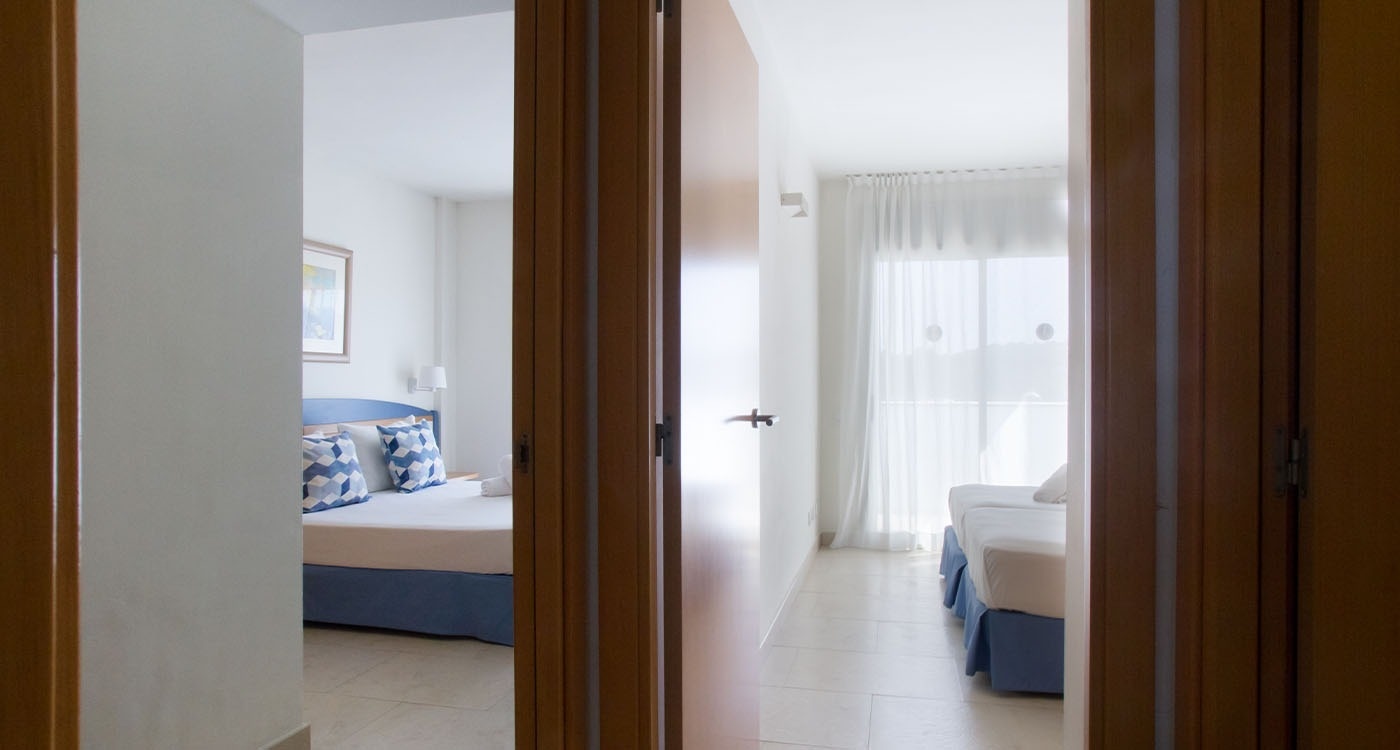 una puerta que conduce a una habitación con una cama y un sofá