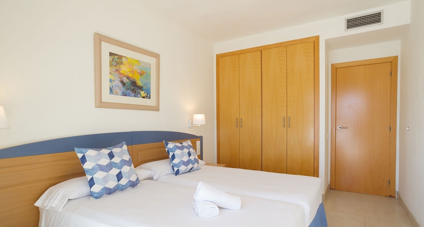 un dormitorio con dos camas y una pintura en la pared