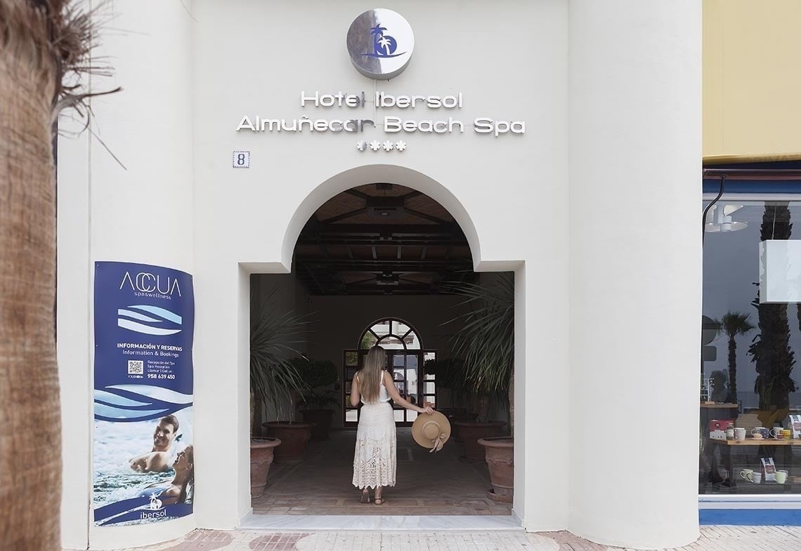 una mujer camina por la entrada del hotel iberosol almunecon beach spa