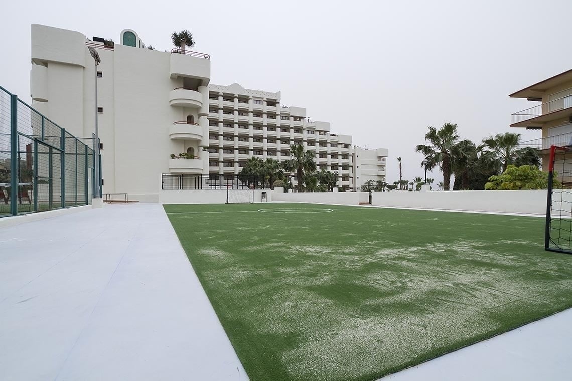 un campo de fútbol con un edificio blanco en el fondo