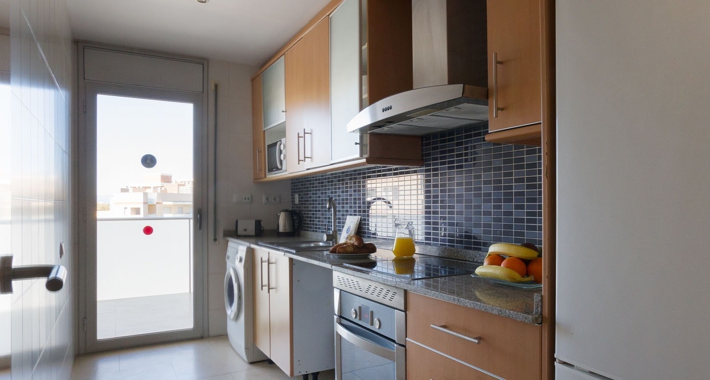 una cocina con electrodomésticos de acero inoxidable y gabinetes de madera