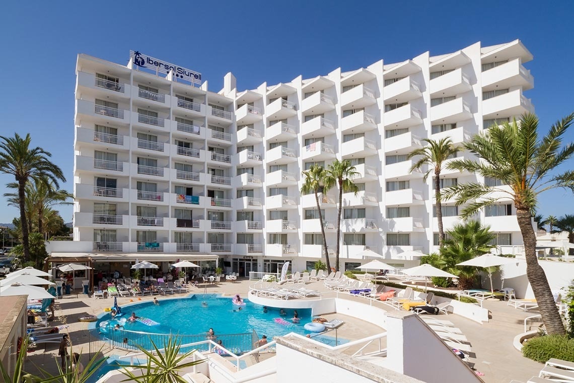 un grande hotel bianco con una grande piscina all'interno