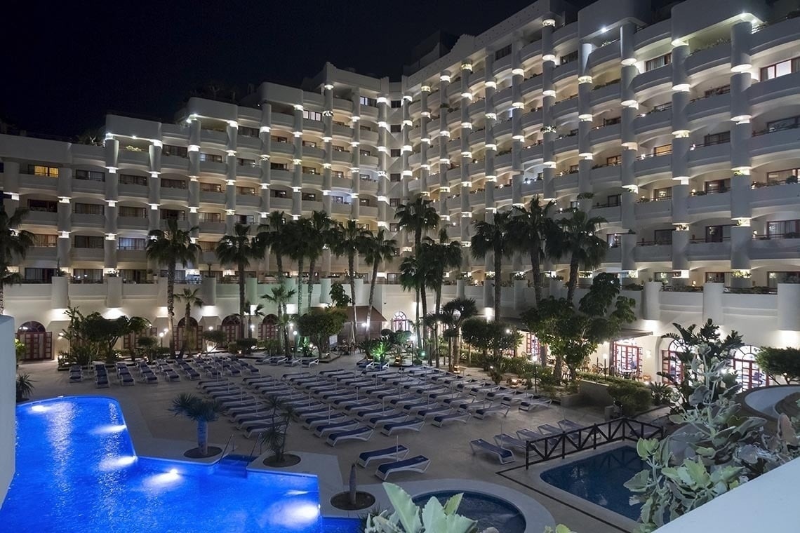 un gran hotel a la nit amb una gran piscina