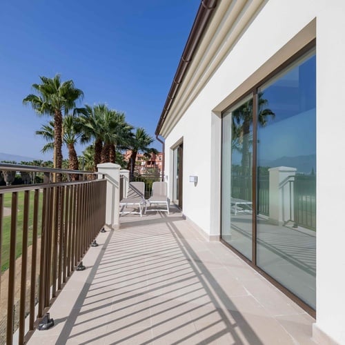 una habitación con dos camas y una pintura azul en la pared