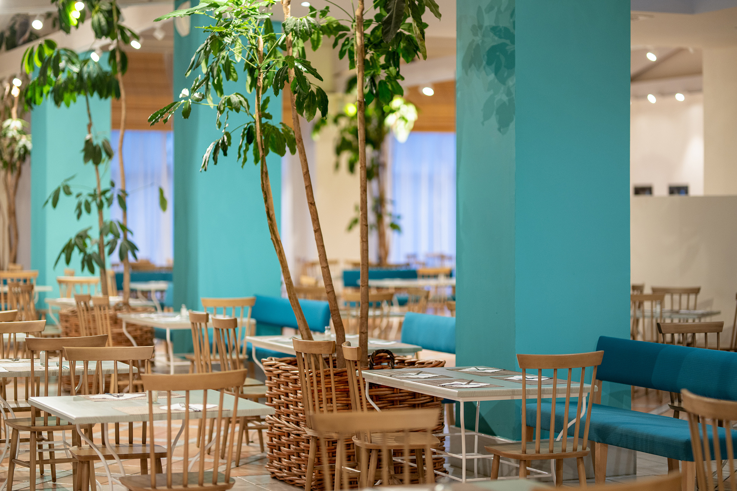 Elegante salón de restaurante de hotel listo para los comensales con plantas Impressive Playa Granada.