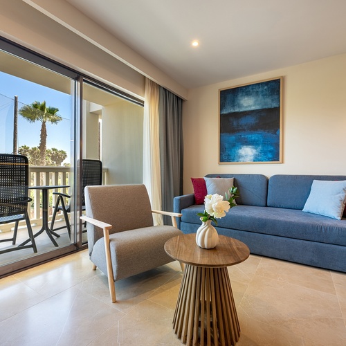 Beeindruckendes Zimmer im Playa Granada mit Kingsize-Bett, blauem Sofa & Balkon.
