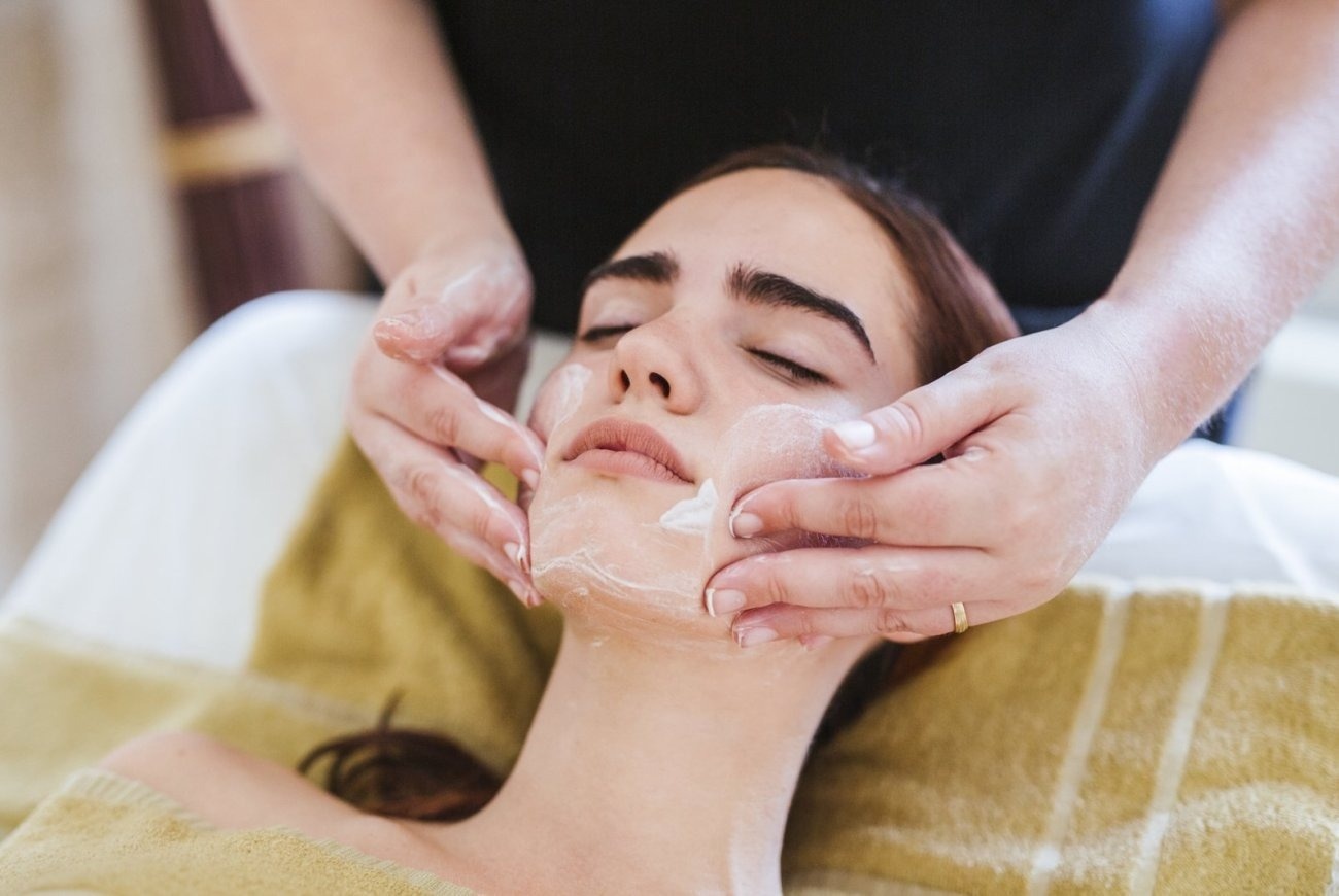 una mujer recibe un masaje en la cara en un spa