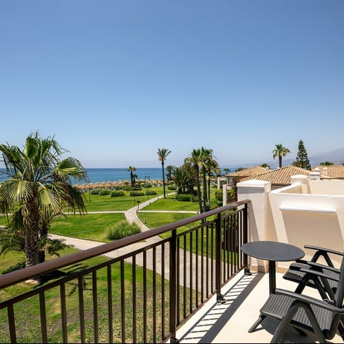 Beeindruckender Balkonblick Playa Granada: Palmen, Rasen, Meer.