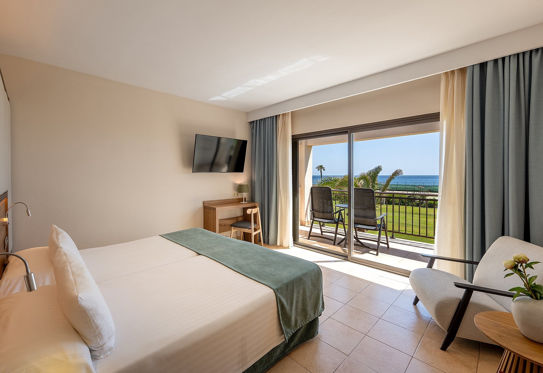 Habitación de hotel moderna con dos camas gemelas, cómoda silla y arte abstracto Habitación Doble vista mar frontal | Impressive Playa Granada.