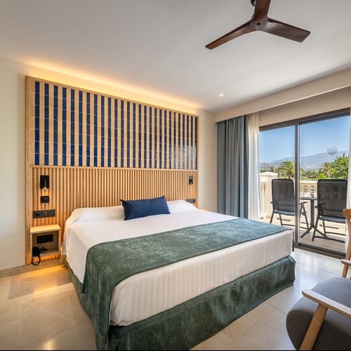 Beeindruckendes Zimmer im Impressive Playa Granada mit bequemem Bett und Schreibtisch.