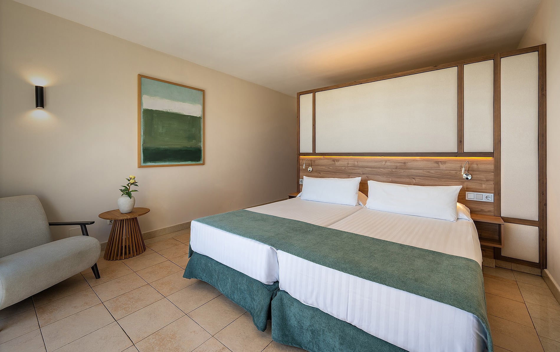 Habitación de hotel con dos camas, silla y cuadro moderno. Habitación Doble vista mar lateral | Impressive Playa Granada