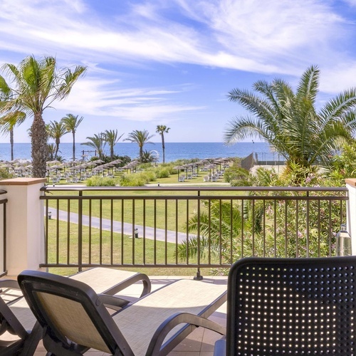 un balcón con una mesa y sillas y una botella de agua