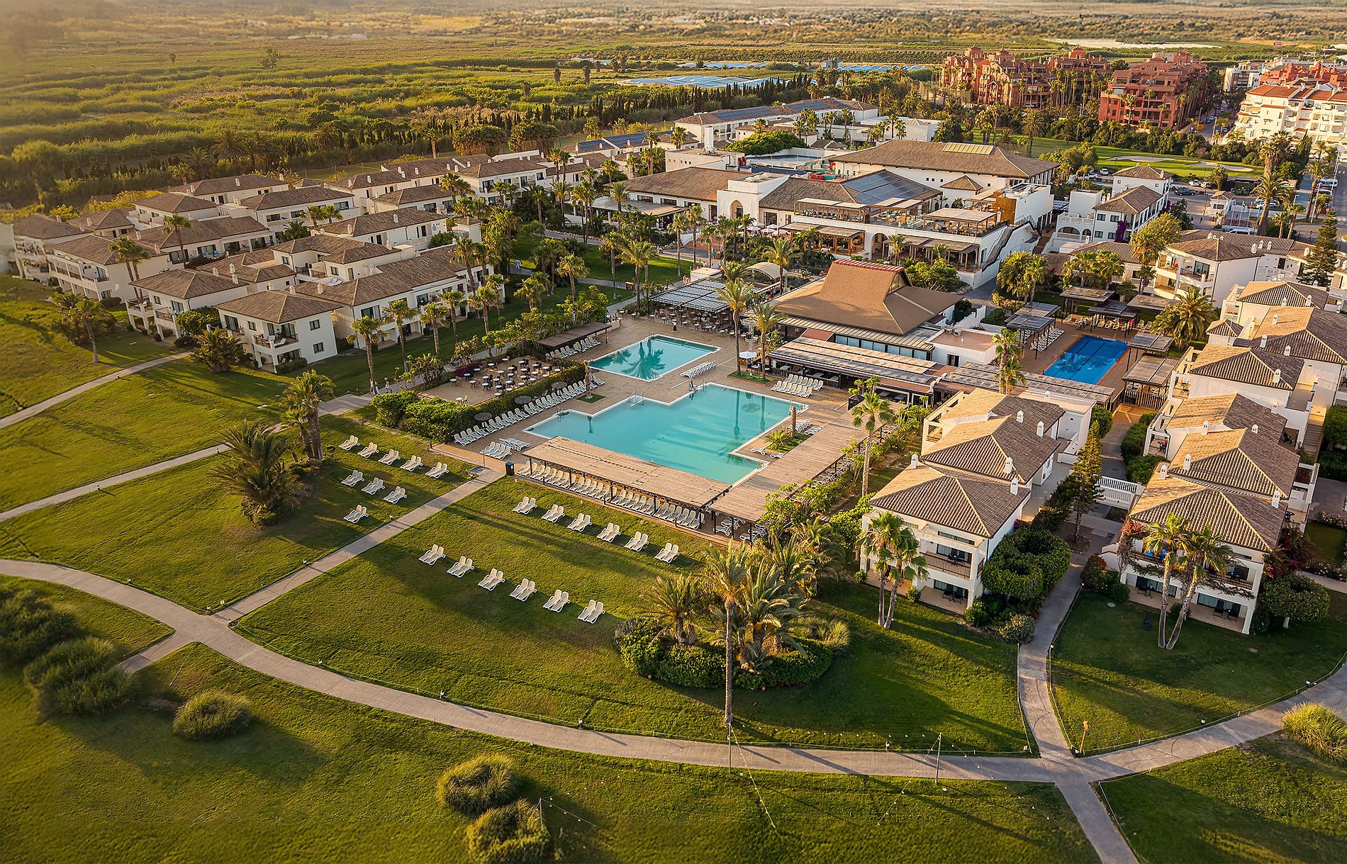 Hotel resort con piscina frente al mar y palmeras, ideal para vacaciones Servicios para toda la familia | Impressive Playa Granada Golf.