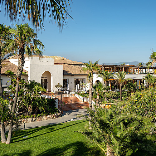 Interior de salón de hotel con ambienteImpressive Playa Granada, sofás y plantas.