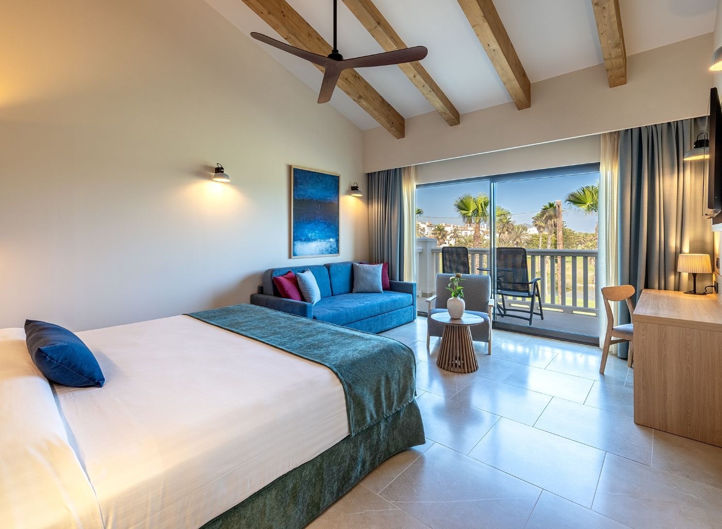una habitación de hotel con una cama y un sofá azul