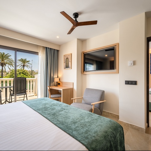 Impressionnante chambre à Impressive Playa Granada, lit confortable et bureau.