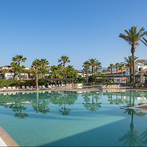 Vista aérea de Impressive Playa Granada resort con piscinas, edificios y césped verde.