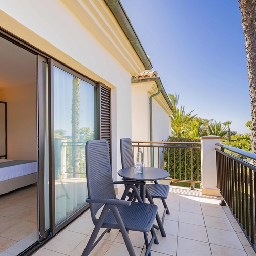 un balcón con una mesa y sillas y una botella de agua