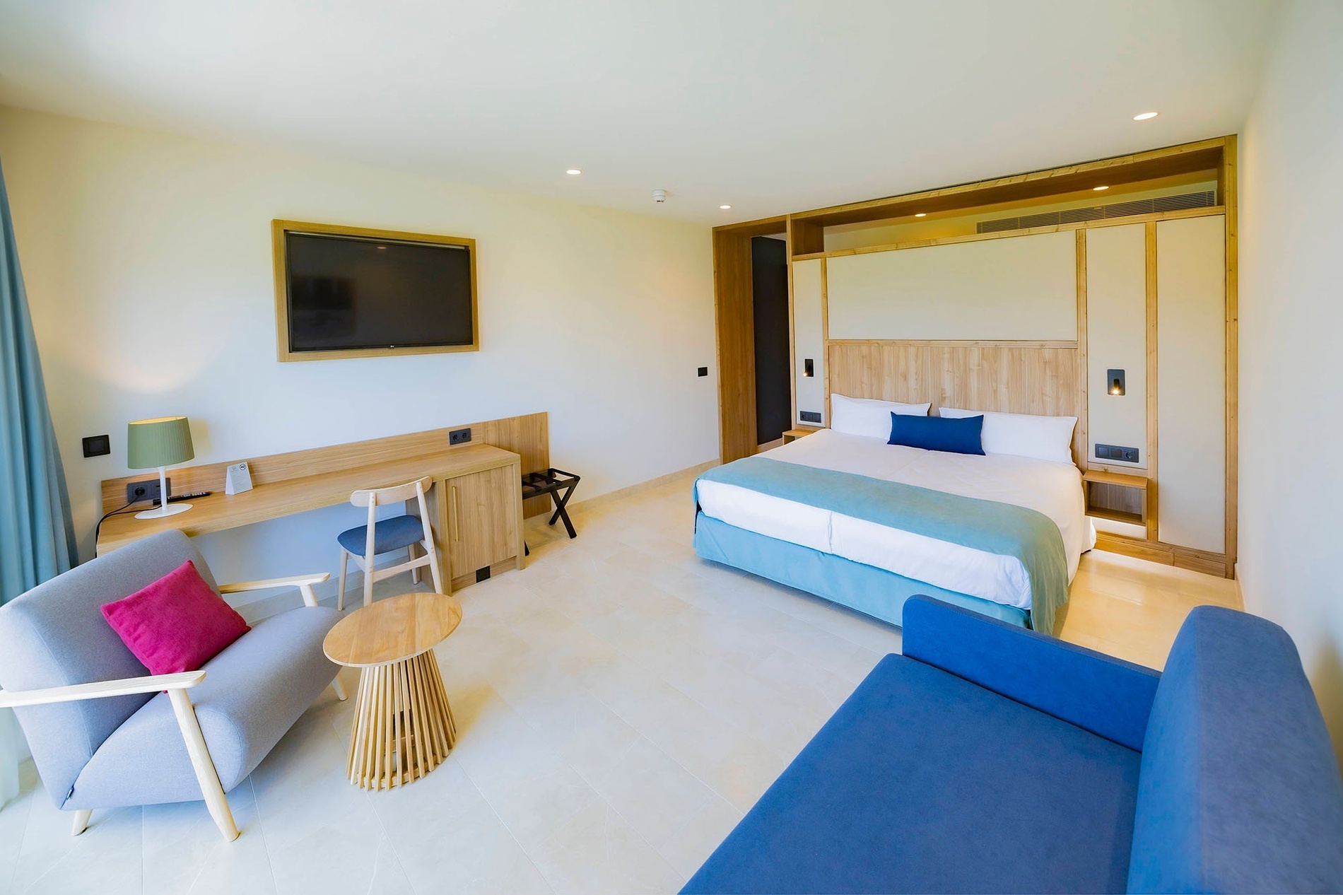 una habitación de hotel con una cama y un sofá azul