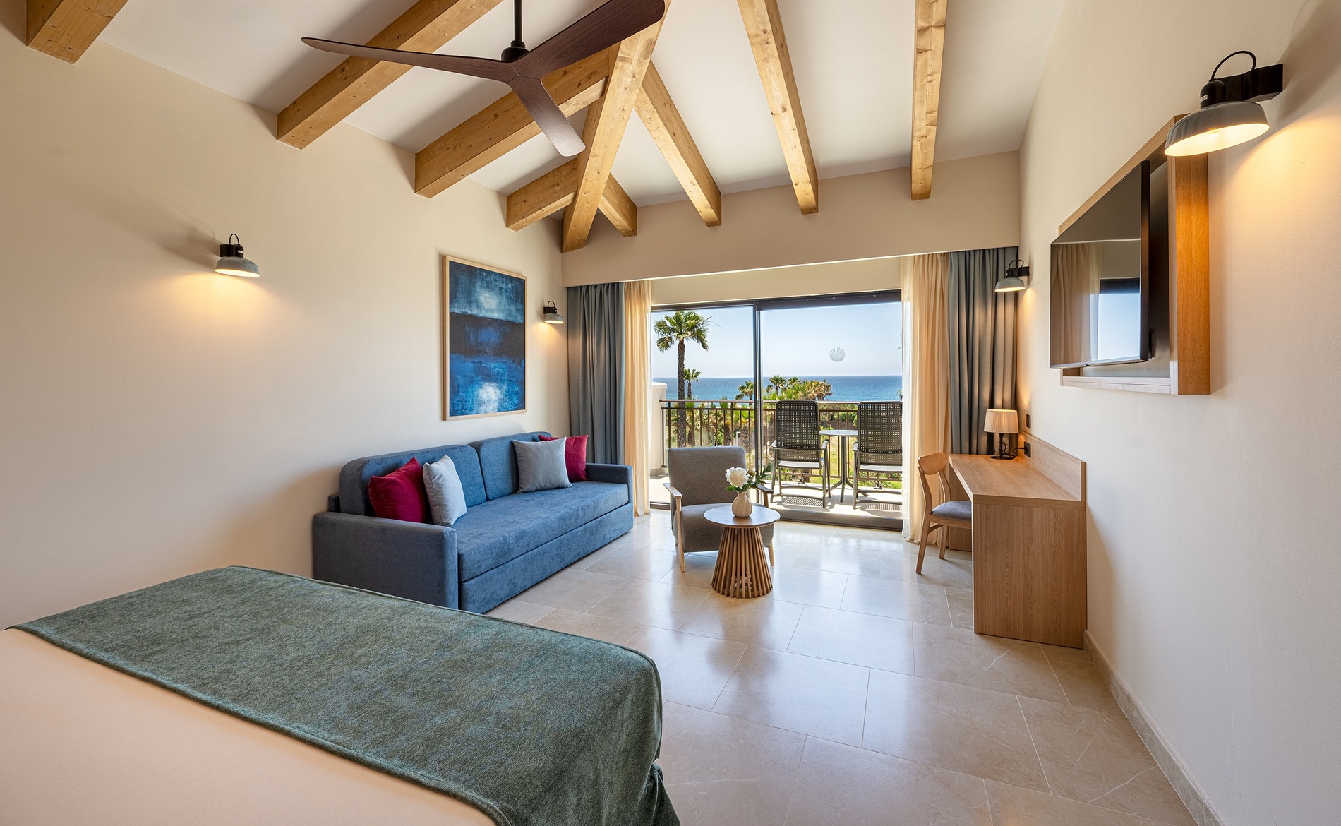 Modern hotel room with sea view balcony, sofa, and desk. Discover our rooms | Impressive Playa Granada Golf