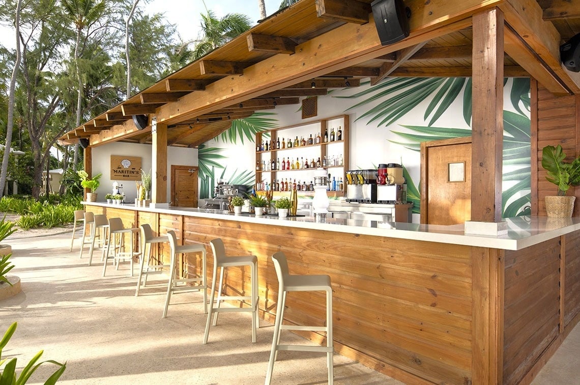 dos hombres juegan al golf en un campo con montañas cubiertas de nieve en el fondo