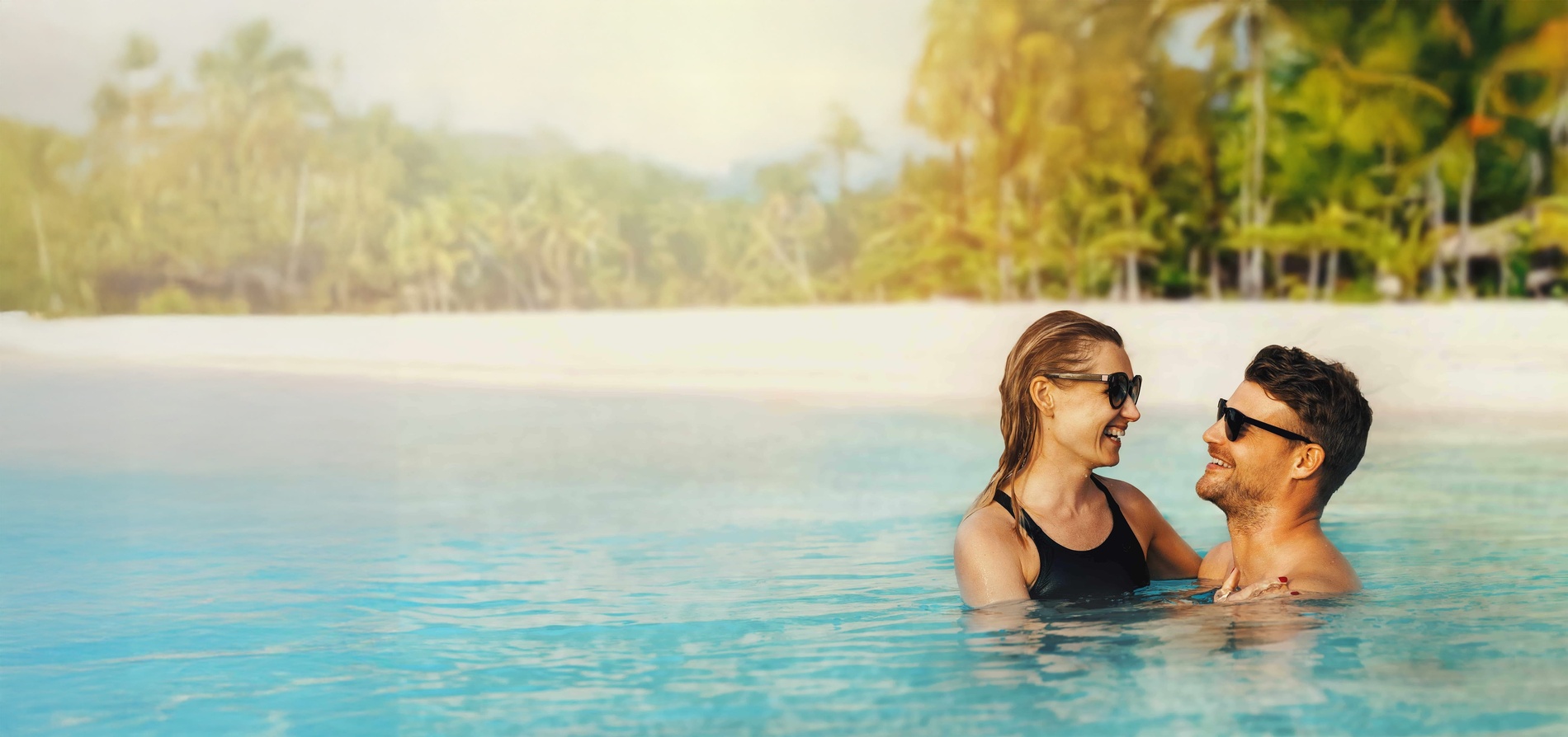 un hombre y una mujer se relajan en una piscina en un resort