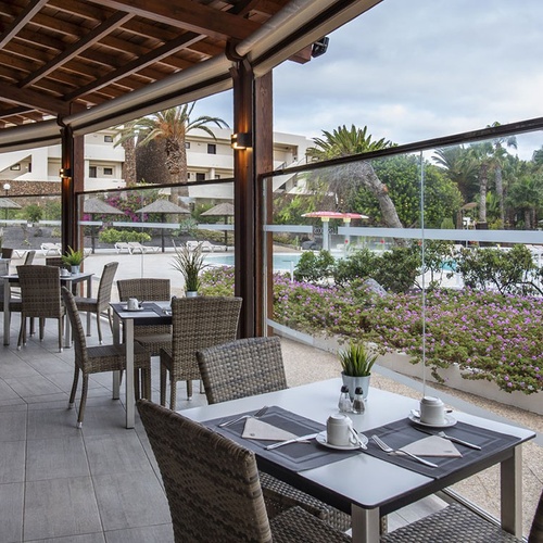 Überdachte Restaurantterrasse mit Poolblick und Pflanzen im Impressive Zocos Lanzarote.