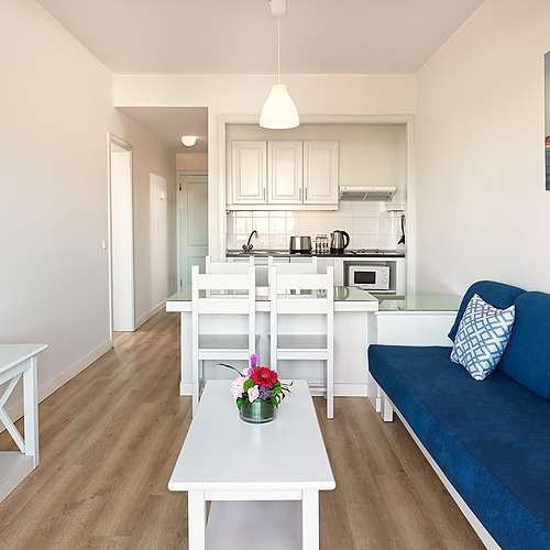 Apartamento luminoso Impressive Zocos Lanzarote: sala con sofá azul, mesa de comedor y TV.