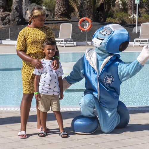 Familienfoto am Pool mit blauem Maskottchen im Impressive Zocos Lanzarote Hotel