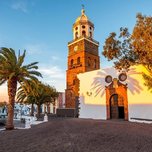 Beeindruckende Zocos Lanzarote: Historische Kirche, Palmen und goldenes Abendlicht.