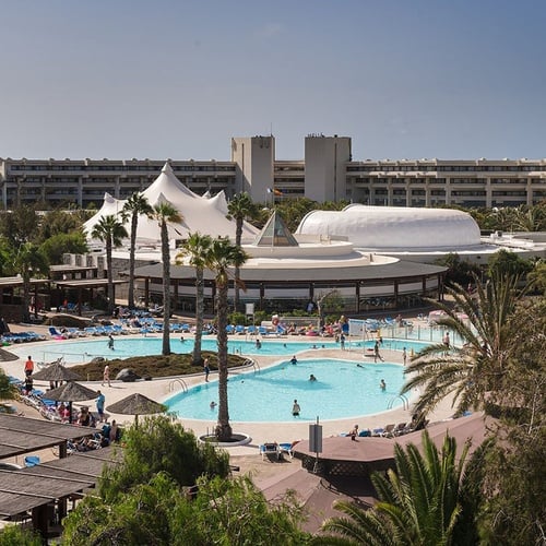 Impressive Zocos Lanzarote: Weitläufige Hotelanlage mit Pools und Palmen unter blauem Himmel.
