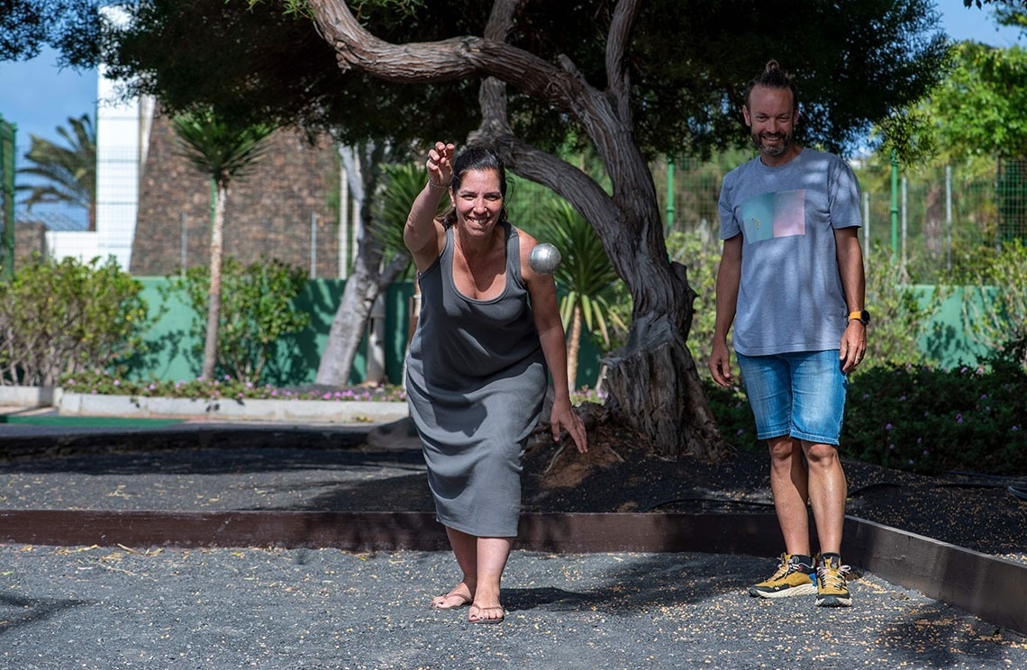 zwei Männer spielen Golf auf einem Golfplatz mit schneebedeckten Bergen im Hintergrund