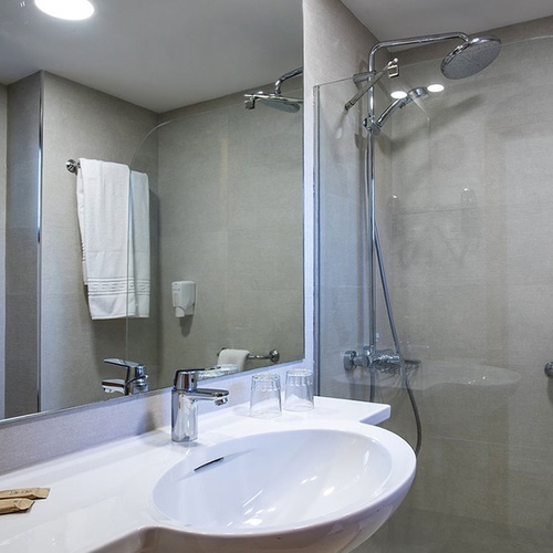 Modernes Badezimmer im Impressive Zocos Lanzarote mit Waschbecken, Spiegel und Duschkabine.