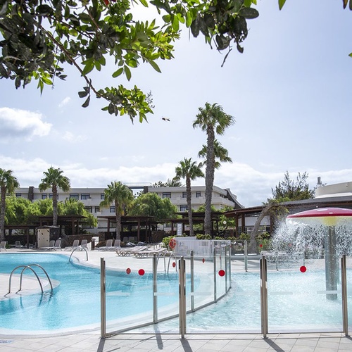 Impressive Zocos Lanzarote Hotel: Poolbereich mit Palmen und Kinderbecken mit Wasserspiel.