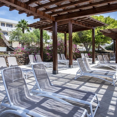 Impressive Zocos Lanzarote: Schattige Liegestühle unter Pergolen, perfekt zur Entspannung im Außenbereich.