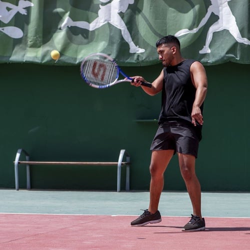 Mann spielt Tennis auf dem Platz, bereit zum Schlag, im Impressive Zocos Lanzarote.