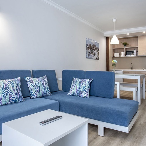 Heller Wohn-/Küchenbereich im Impressive Zocos Lanzarote Apartment mit stilvollem Sofa.