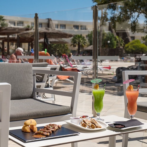 Sonnige Terrasse im Impressive Zocos Lanzarote mit leckeren Cocktails, Snacks & Poolblick.
