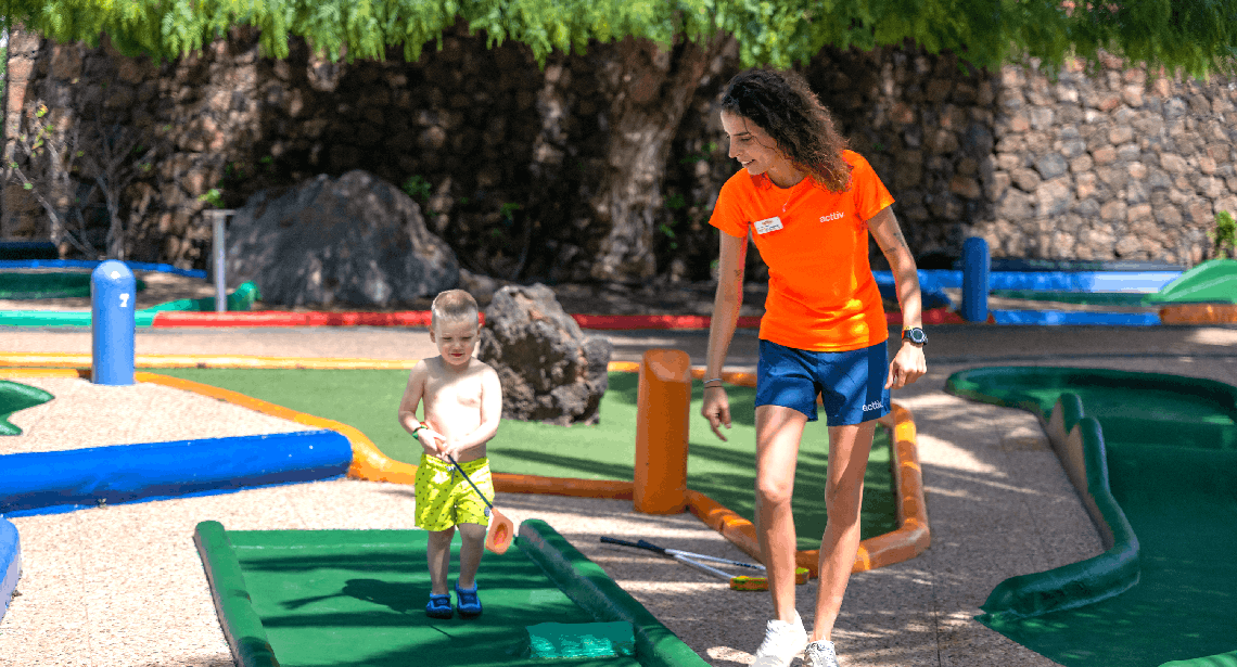 zwei frauen sitzen an einem tisch vor einem restaurant mit delfinen an der wand