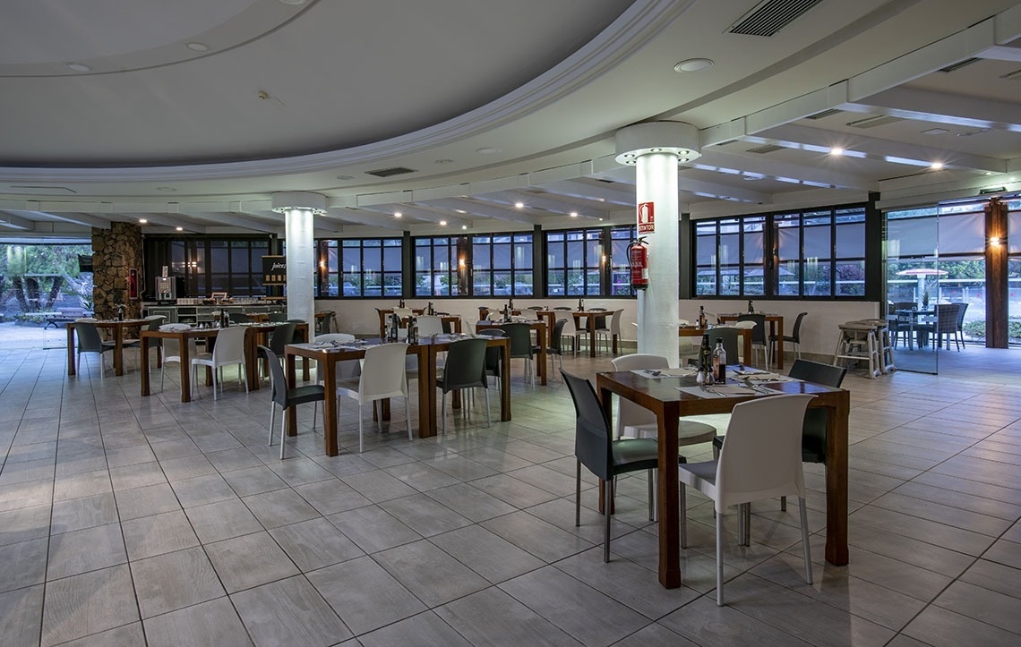 ein Tisch und Stühle stehen vor einem großen Fenster