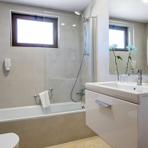 Helles, modernes Badezimmer im Impressive Zocos Lanzarote mit Badewanne, Dusche und elegantem Waschtisch.