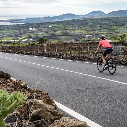 Radfahrer auf Panoramastraße mit Blick auf die beeindruckende Zocos Lanzarote Küste.